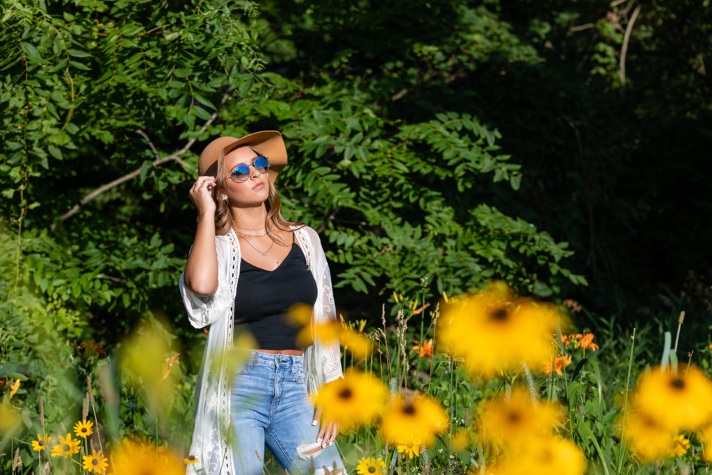 young woman posing in large brown hat outdoors in Blommington.