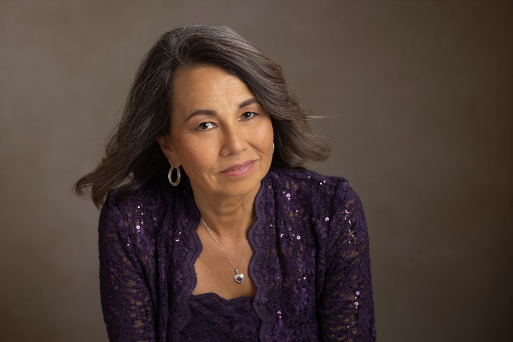 Over 40 woman posing for camera against brown backdrop