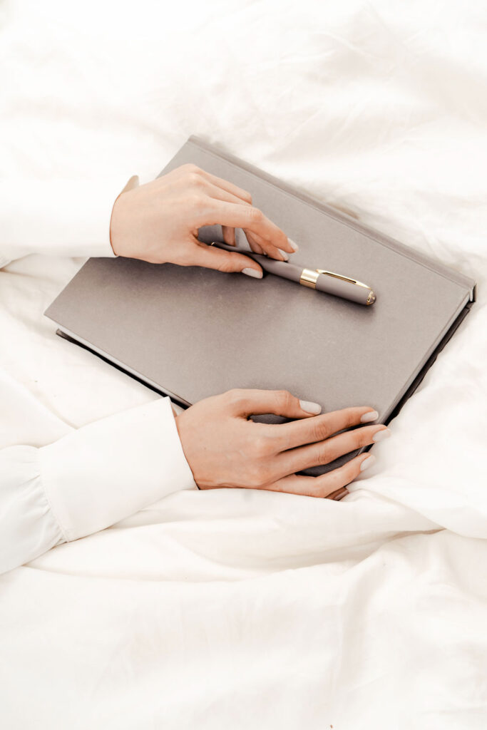 Women holding a laptop and a pen