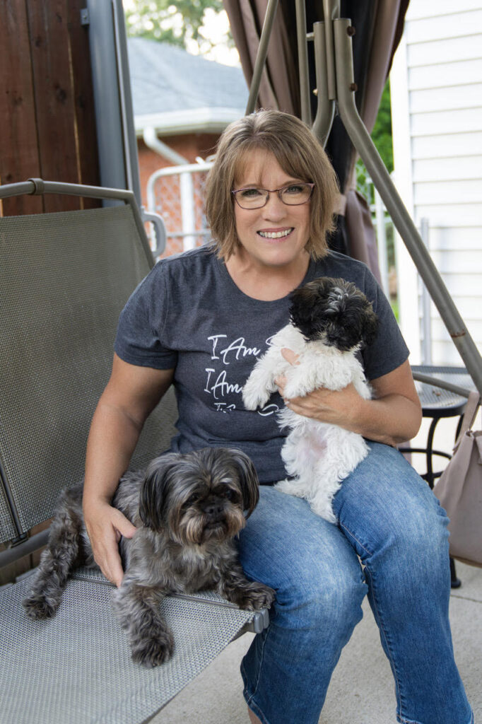 Karen sitting with her two small pet dogs